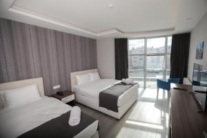 a hotel room with two beds and a television at Grand Dost Hotel in Osmancık +81 photos