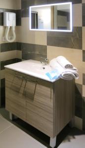 a bathroom with a sink and a mirror at Hôtel La Source in Lourdes