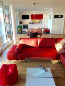 a living room with a red couch and a table at Rhein Melodie riverview luxury in Konstanz