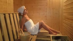 a woman sitting in a sauna with a towel on her head at Hotel Chichin in Bansko