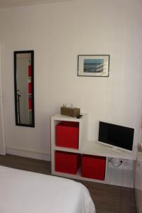 Appartement Quai Ouest في دْييب: غرفة نوم مع تلفزيون وسرير مع أدراج حمراء