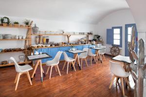 - un restaurant avec des tables et des chaises dans une salle dans l'établissement Meltemi Suites, à Perissa