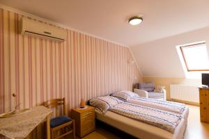 a small bedroom with a bed and a chair at Alíz Vendégház in Békéscsaba