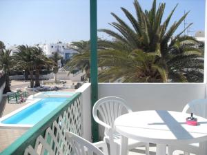 balkon ze stołem i krzesłami oraz basen w obiekcie Irene Apartment w Puerto del Carmen