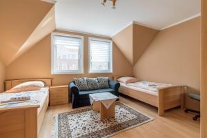 ハノーファーにあるPrivate Rooms Hannover - Room Agencyのベッド2台とソファが備わる客室です。