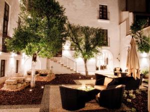 a courtyard with couches and trees in front of a building at Eurostars Patios de Cordoba in Córdoba