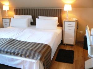 um quarto de hotel com uma cama grande e duas lâmpadas em Waldhotel "Peter aufm Berge" em Bielefeld