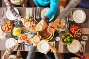 um grupo de pessoas sentadas à volta de uma mesa com comida em 湖上館パムコ em Wakasa
