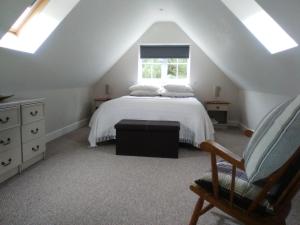 Schlafzimmer im Dachgeschoss mit einem Bett und einem Fenster in der Unterkunft Waterside Cottage in York