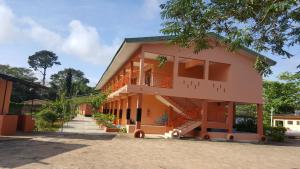 a pink building with a staircase in front of it at Hans Cottage Botel in Cape Coast