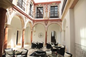 um restaurante com mesas e cadeiras num edifício em Eurostars Patios de Cordoba em Córdoba