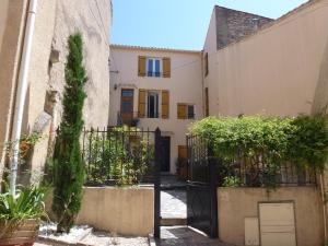 a villa with a gate in front of a building at Comfortable Gite (2) in attractive Languedoc Village in Magalas