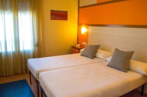 a hotel room with two beds and a window at Hotel Maestrazgo de Calatrava in Almagro
