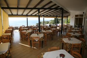 a restaurant with tables and chairs with the ocean in the background at Hotel Glicorisa Beach in Pythagoreio