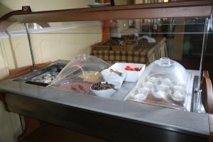 un buffet con algo de comida en recipientes de plástico en un mostrador en Hotel Glicorisa Beach en Pythagoreio