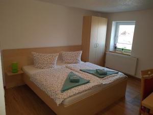 a bedroom with a bed with two green dishes on it at Landsauna - Pension in Zittau