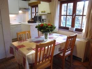 una cocina con una mesa con un jarrón de flores. en Cosy and snug holiday home with joint swimming pool, en Zichemsveld