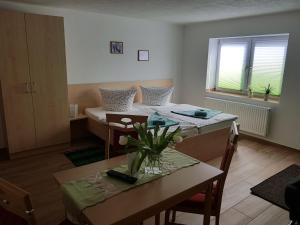 uma sala de estar com duas camas e uma mesa em Landsauna - Pension em Zittau