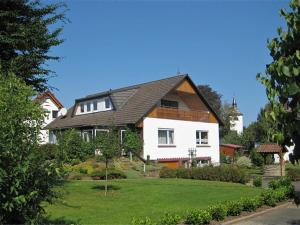 a white house with a black roof and a yard at Quiet apartment in Merlsheim with balcony in Nieheim