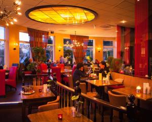 ein Restaurant mit Leuten, die in einem Restaurant an Tischen sitzen in der Unterkunft Hotel Restaurant Het Roode Hert in Dalfsen