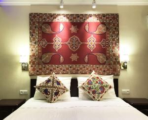 a bedroom with a bed with a red headboard at Jahongir Guest House in Samarkand
