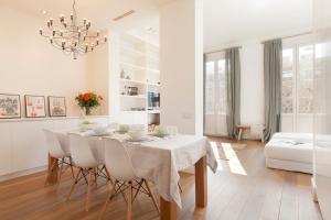 a white dining room with a table and chairs at Click&Flat Luxury Sant Joan in Barcelona