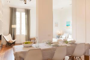 a white dining room with a table and chairs at Click&Flat Luxury Sant Joan in Barcelona +16 photos