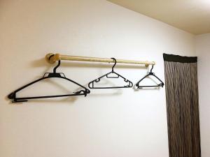 a towel rack with two hangers on a wall at Osaka Tengachaya Guesthouse SAYURI II in Osaka