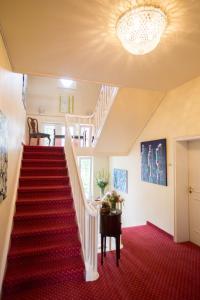 eine Treppe in einem Haus mit rotem Teppich in der Unterkunft Hotel Villa Meererbusch in Meerbusch