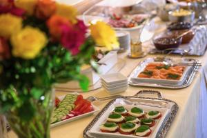una mesa cubierta con bandejas de comida y flores en Hotel Villa Meererbusch en Meerbusch