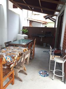 a patio with a table and chairs in a room at Pousada Chalés Vereda do Sol in Ubatuba