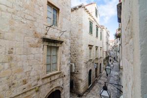 eine Gasse in einer Altstadt mit Steingebäuden in der Unterkunft Apartment Josipa in Dubrovnik