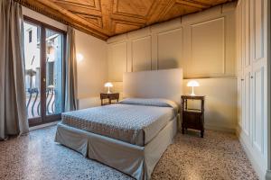 ein Schlafzimmer mit einem Bett und einem großen Fenster in der Unterkunft Sartor Apartment with Canal View and Private Court in Venedig