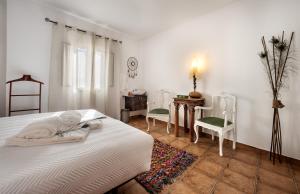 1 dormitorio con 1 cama, mesa y sillas en Peacock House, en Évora