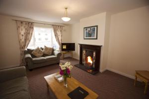 un salon avec une cheminée et un canapé dans l'établissement Seacrest Holiday Homes by Trident Holiday Homes, à Bundoran