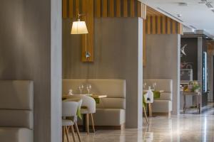 a dining room with white chairs and a table at ESTIMAR Calpe Suitopia in Calpe