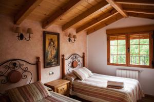sypialnia z dwoma łóżkami i oknem w obiekcie Alojamiento Rural Casa Inocente w mieście La Toba