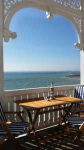 a wooden table on a balcony with a view of the ocean at Fuerstenhof Appartement 401 in Sassnitz