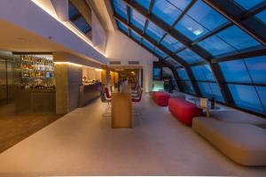 a lobby of a building with red chairs and a bar at ESTIMAR Calpe Suitopia in Calpe