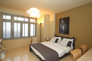 a bedroom with a large bed and a chandelier at Canal Studio Apartment in Amsterdam