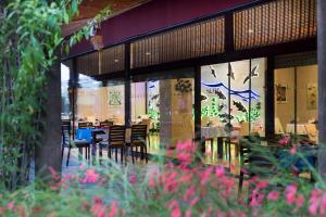 restauracja ze stołami, krzesłami i kwiatami na pierwszym planie w obiekcie Siam Elegance Hotel & Spa w mieście Belek