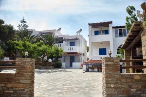 a group of white houses with a stone courtyard at Irene Studios in Agios Petros