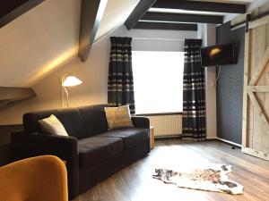 un soggiorno con divano e finestra di MeerZee a Vrouwenpolder