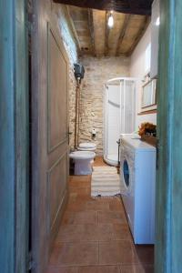 a bathroom with a toilet and a washing machine at Appartamenti turistici Vicolo S. Chiara in Sassoferrato