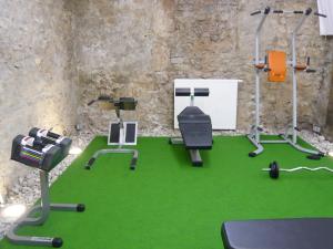 a room with a gym with green flooring and exercise equipment at Hotel Kolping Hallein in Hallein