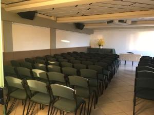 a conference room with chairs and a table and a podium at Manferrari Hotel in Contagem