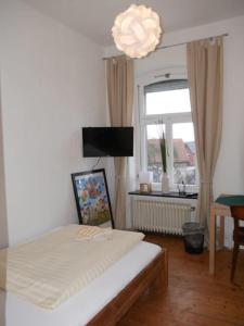 1 dormitorio con cama, ventana y lámpara de araña en Alte Schmiede, en Ascheberg