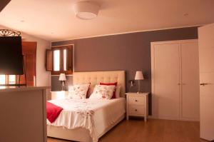 a bedroom with a white bed with red pillows at Casa Del Beso in Luarca