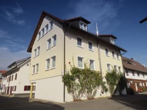 biały budynek z brązowym dachem w obiekcie Hotel & Restaurant Mainaublick w mieście Uhldingen-Mühlhofen