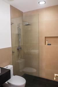y baño con ducha de cristal y aseo. en La Coupole Hotel, en Quito